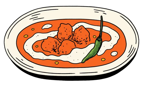 A bowl of butter chicken in creamy tomato gravy, topped with a green chilli.